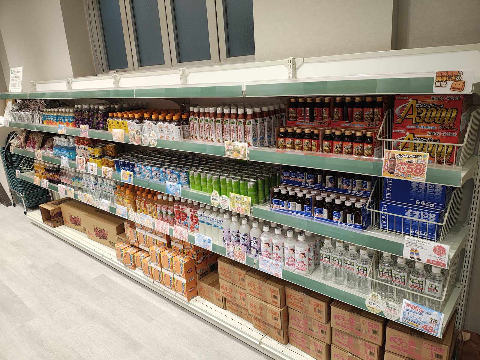 飲料と調味料の棚。ペットボトル飲料や紙パック飲料、しょうゆなどの調味料が並ぶ